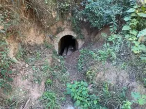 Tubo de drenaje descargando en una quebrada.