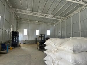 Interior bodega industrial, sacos blancos a la vista